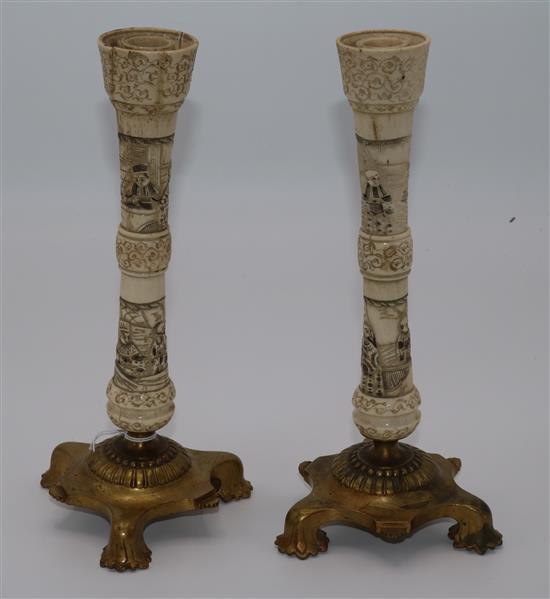 A pair of Japanese carved bone candlesticks, on brass bases